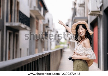 Happy asian youth woman with camera travels street city trip on leisure weekend. Young hipster female tourist sightseeing summer urban Bangkok destination. Asia summer tourism concept.