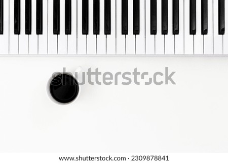 Flat lay musical background with musical keyboard and coffee cup, musical minimalism, space for text.