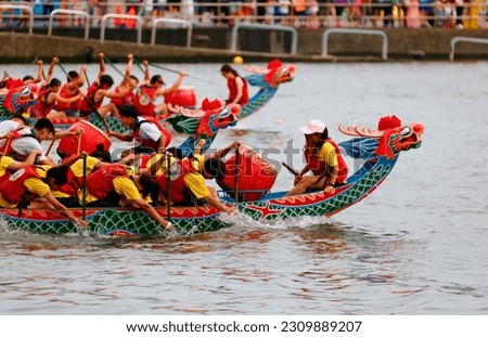 A competitive racing on Keelung River in the traditional Dragon Boat Festival in Taipei, Taiwan, where the women athletes pull vigorously on the oars to the pace of the drumbeats by the team leaders