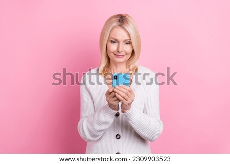 Photo of positive lady hold use smart phone typing chatting social network isolated on pink color background