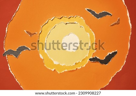 Layers of colored paper with torn edges. Birds in front of the sun. Abstract background in warm colors.