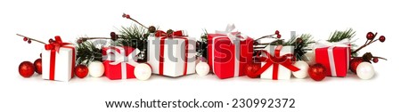 Christmas border of branches and red and white gifts over a white background
