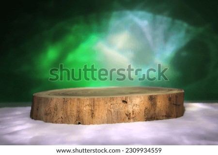 Sawn tree podium, on white fabric, on a dark background. Beautiful northern lights on the background. Presentation of products. High quality photo