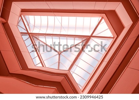 Fragment of abstract modern architecture. Photo of the interior staircase balcony walls in pinkish red with glass ceiling structure. Geometric or graphic design concept for wallpaper. trend