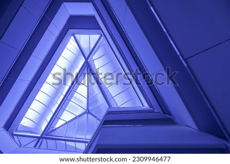 Interior staircase of building with glass roof structure, wide angle abstract background view. Fragment of blue interior with ceiling. Successful concept, industrial, architecture, office, building.