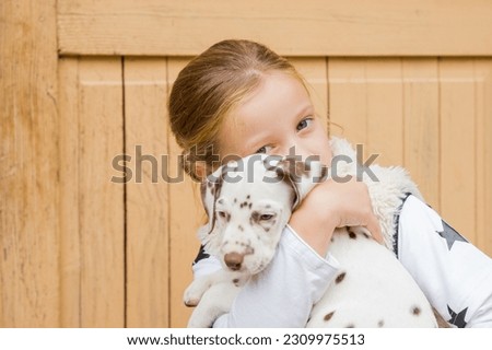 Kids play with cute little puppy. Children and baby dogs playing in sunny summer garden. Little girl holding puppies. Child with pet dog. Family and pets on park lawn. Kid and animals friendship.