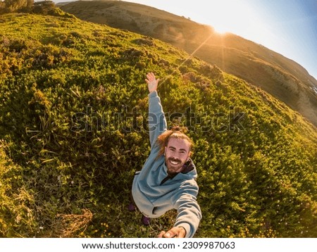 man taking a selfie in the nature at sunrise surrounded by green plants