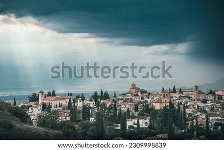 Views over Albaicín, Granada. The picture portrays a captivating scene with an approaching thunderstorm