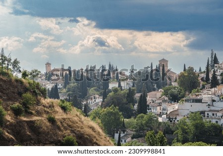 Views over Albaicín, Granada. The picture portrays a captivating scene with an approaching thunderstorm