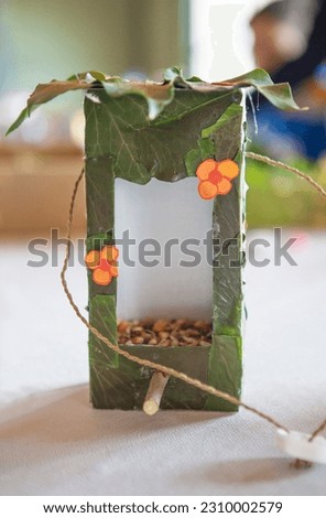 Bird feeder made with recycled materials. Crafts made by children in a nature workshop Royalty-Free Stock Photo #2310002579