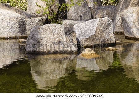 picture of large rocks at a pond of a landscaped Japanese garden