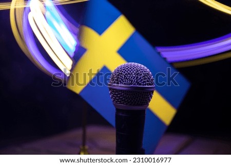 Microphone on a background of a blurry flag Sweden close-up. dark table decoration. Selective focus