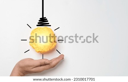 Hand holding Yellow scrap paper ball with illustration painting for virtual lightbulb. It is creative thinking idea for problem solving and innovation concept.