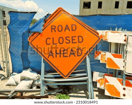 Road closed signage piled at construction site. 