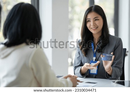 Young businesswoman, company employee presenting a form of credit limit, benefits, how to use the card , coverage amount, insurance ,interest rate to customer for choice. Payment. Loan concept. Royalty-Free Stock Photo #2310034471