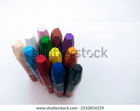 Multicolored crayons standing upright isolated on white background
