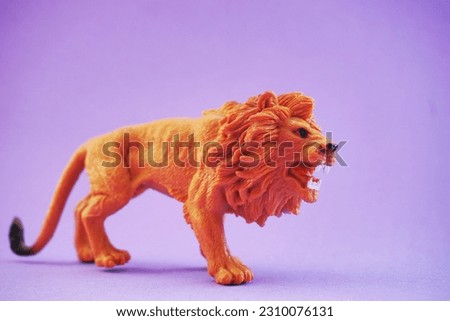 Close up of a lion character kids toy on a glamorous purple background