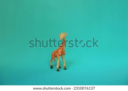 Front view of a giraffe character kids toy on a turquoise blue  background