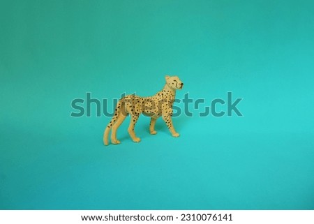 Side  view of a Cheetah character kids toy on a turquoise blue background