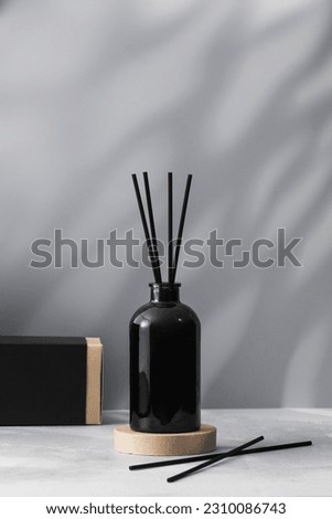 Bamboo sticks in a black bottle with indoor perfumes. Glass diffuser with fragrance for home. Royalty-Free Stock Photo #2310086743