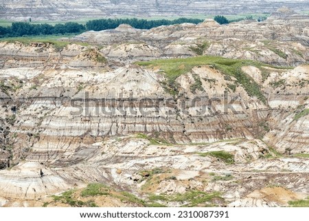 Badlands rock strata of Drumheller Valley, Dinosaur provincial park, Drumheller, Alberta, Canada. Royalty-Free Stock Photo #2310087391