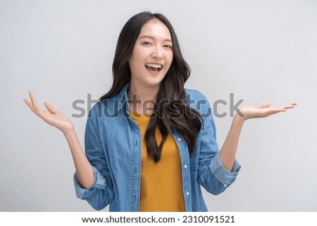 Smiling positive, attractive asian young woman, girl hand show product advertising in casual, portrait of beautiful brunette her with long hair, feeling happy standing isolated on white background.