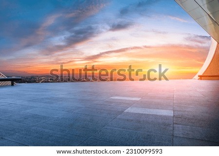 Empty square floor and city skyline at sunset