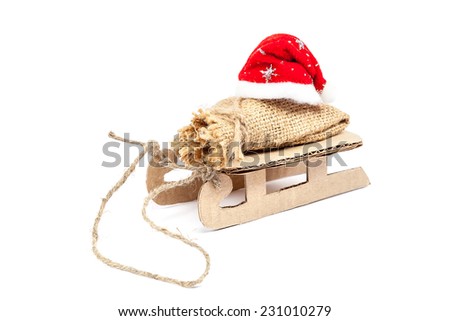 Sleigh with a sack and a Santa Claus hat isolated on white background.