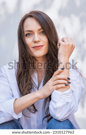 Beautiful young woman smiling against the sun. Attractive young woman having green eyes and long brunette hair. Copy space. Lifestyle concept.
