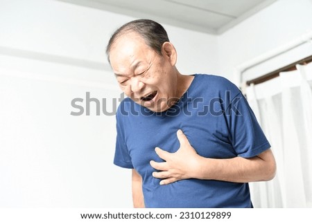 Asian elderly man holding his chest with a painful expression
 Royalty-Free Stock Photo #2310129899
