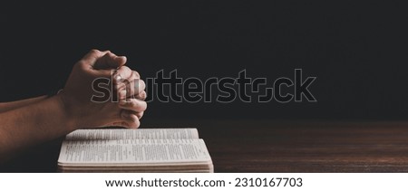 Hands folded in prayer on a Holy Bible in church concept for faith. banner with copy space