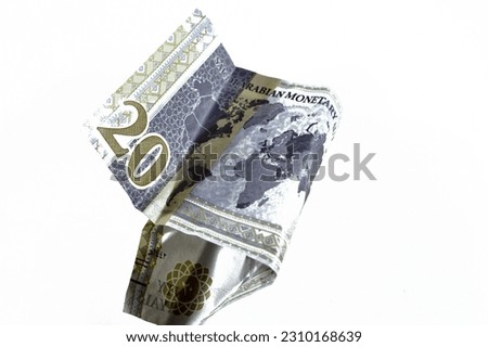 Crumpled Saudi Arabia money of 20 SAR twenty riyals with G20 summit logo, photo of king Salman, world map, wrinkled cash bill banknote, Saudi money inflation and economy world crisis concept