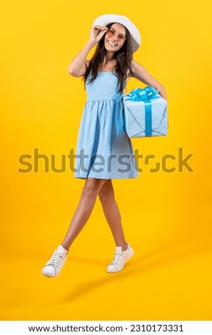 photo of carefree birthday woman hold present. birthday woman hold present isolated on yellow.
