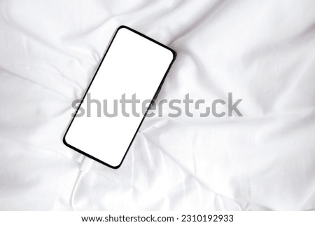 White blank screen smartphone for inserting pictures or advertising text on white fabric. Clipping path. Copy space.