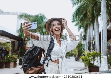 young latin woman tourist backpacker taking a photo selfie in Mexico Latin America with tropical background, hispanic girl in caribbean city