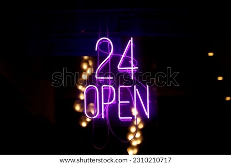 Purple neon light inside a restaurant stating: "24 open".