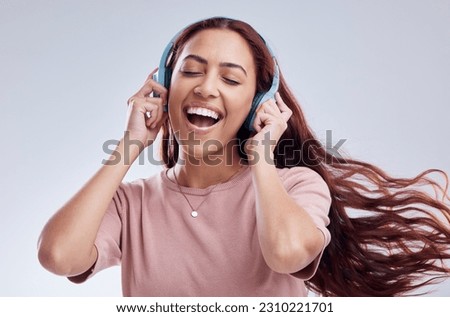 Dance, headphones or happy woman singing music or radio audio smiling in studio on white background. Dancing, smile or excited gen z girl streaming or listening to online song playlist in freedom
