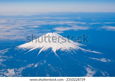 Top view of the Japan icon Mt Fuji from the airplane. Mt. Fuji seen from the window of an airplane. bird eye view of fuji mountain, famous volcano in japan, shot from airplane window.