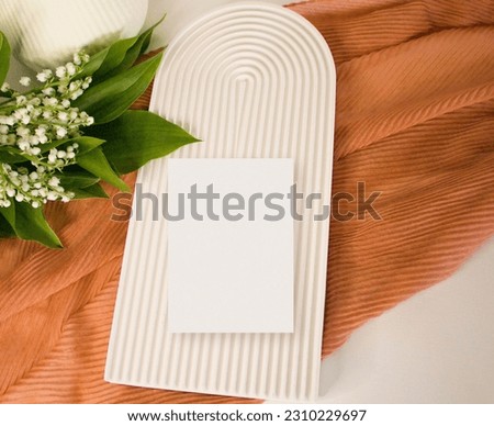 Paper card mockup with lily of the valley leaves and decor