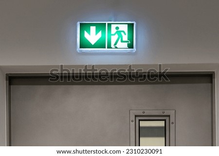 Emergency exit sign in an office building. Underground garage.