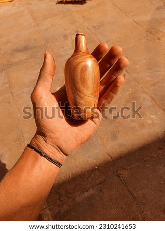 In the photo, a hand on the left delicately holds a handmade vase, showcasing the artistry and craftsmanship that went into its creation. The hand's gentle grasp emphasizes the care and appreciation f Royalty-Free Stock Photo #2310241653