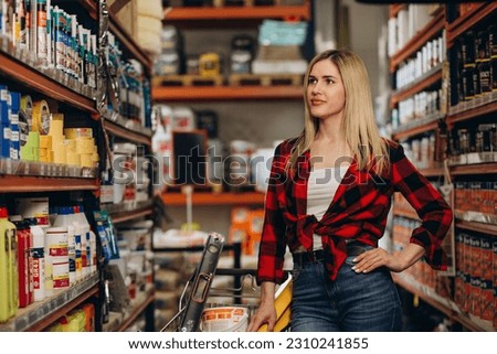 Portrait of female customer holding cellphone and screwdriver in hardware store Royalty-Free Stock Photo #2310241855