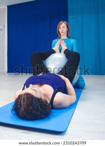 fitness for pregnant women on a fitness ball, trainer and pregnant woman, yoga for pregnant women