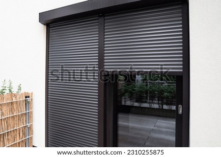 View of building with big windows and black roller shutters outdoors Royalty-Free Stock Photo #2310255875