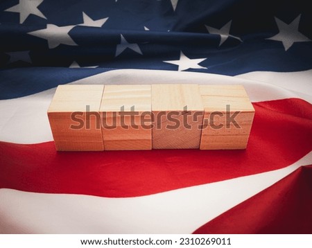 Four wooden cubes on the American flag background. Space for text.