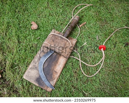 Scythe or Sickle knife or sabit in a scabbard or cangklekkan or angklek or eklek made of wood. Scythe, celurit (sickle) is an agricultural tool in the form of a knife curved to resemble a crescent Royalty-Free Stock Photo #2310269975