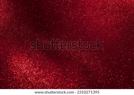 Abstract strains of gold particles in a red liquid. A mysterious glistening fluid background. Golden glittering particles on dark red background. Royalty-Free Stock Photo #2310271395