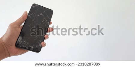 Hand's man holding black smartphone with a broken screen isolated on white background