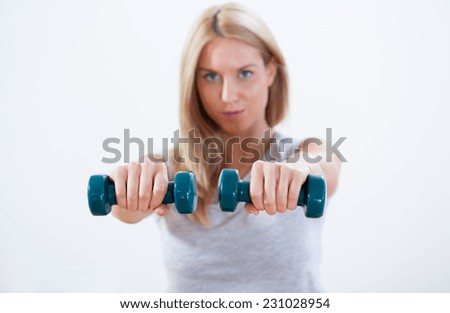 Portrait of beauty woman training with dumbbells