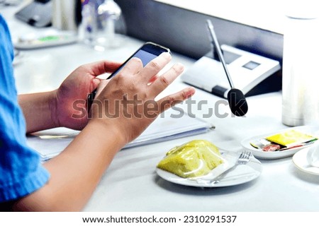 Close-up image of a woman using mobile phone in a cafe